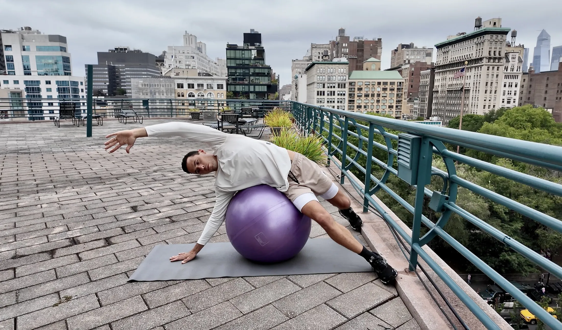 Blair stretching over a stability ball on a rooftop