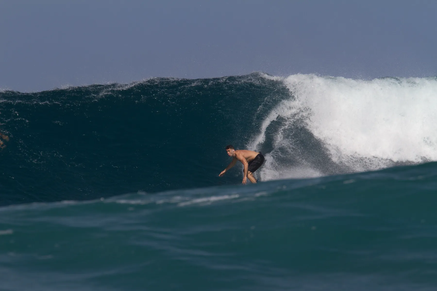 Blair dropping into a dark blue wave